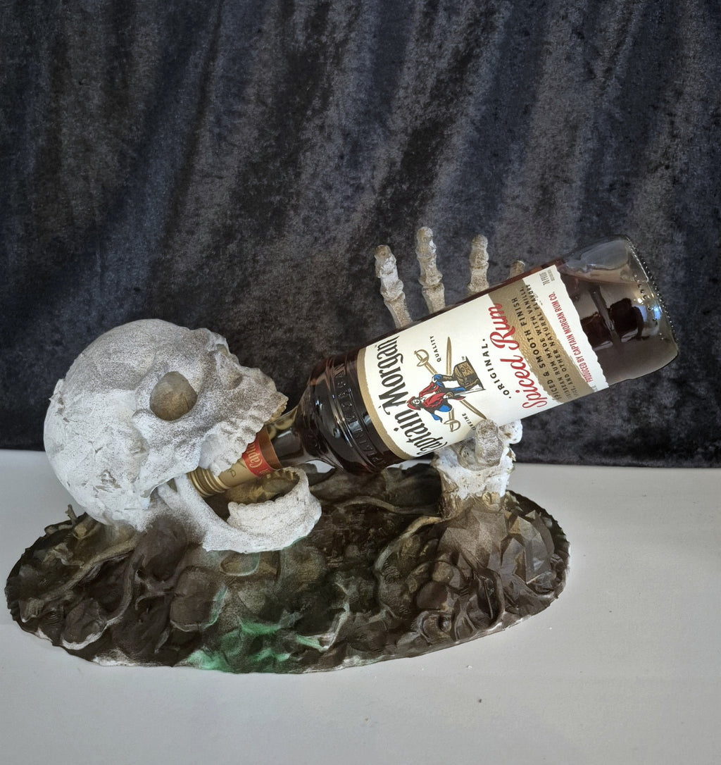 Skeleton skull and hand bottle holder with Captain Morgan rum bottle